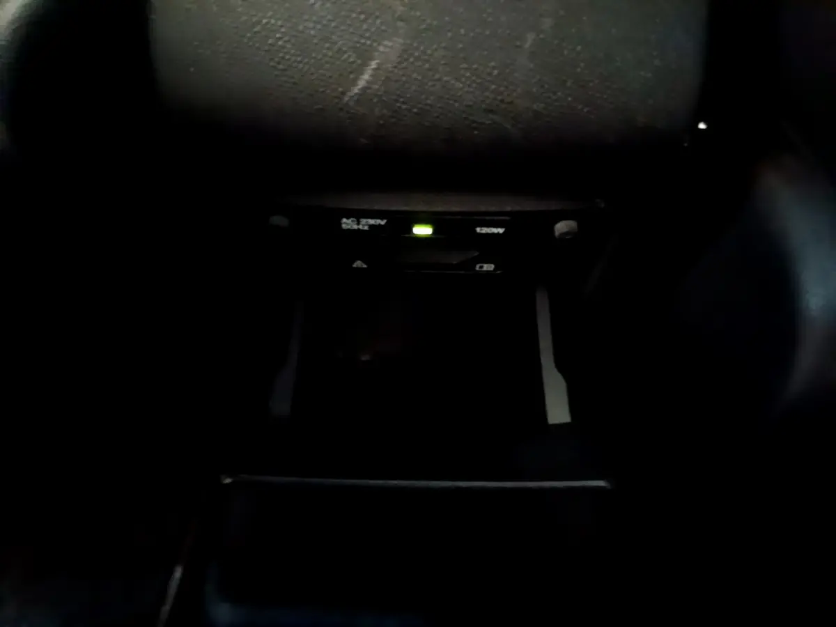 Prise 230V 120W avec témoin lumineux dans l'habitacle sombre d'une Peugeot 308 GT Line gris foncé 2016