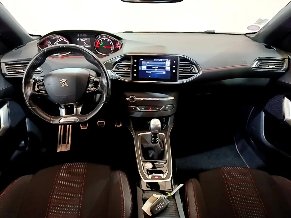 Intérieur de la Peugeot 308 GT Line 2016, vue frontale du tableau de bord avec volant cuir et écran tactile central.