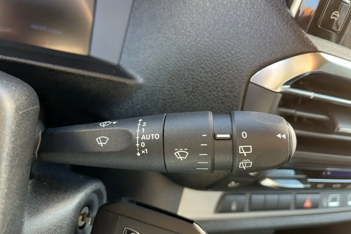 Gros plan sur la commande d’essuie-glace côté gauche du tableau de bord du Peugeot Traveller gris acier 2025.