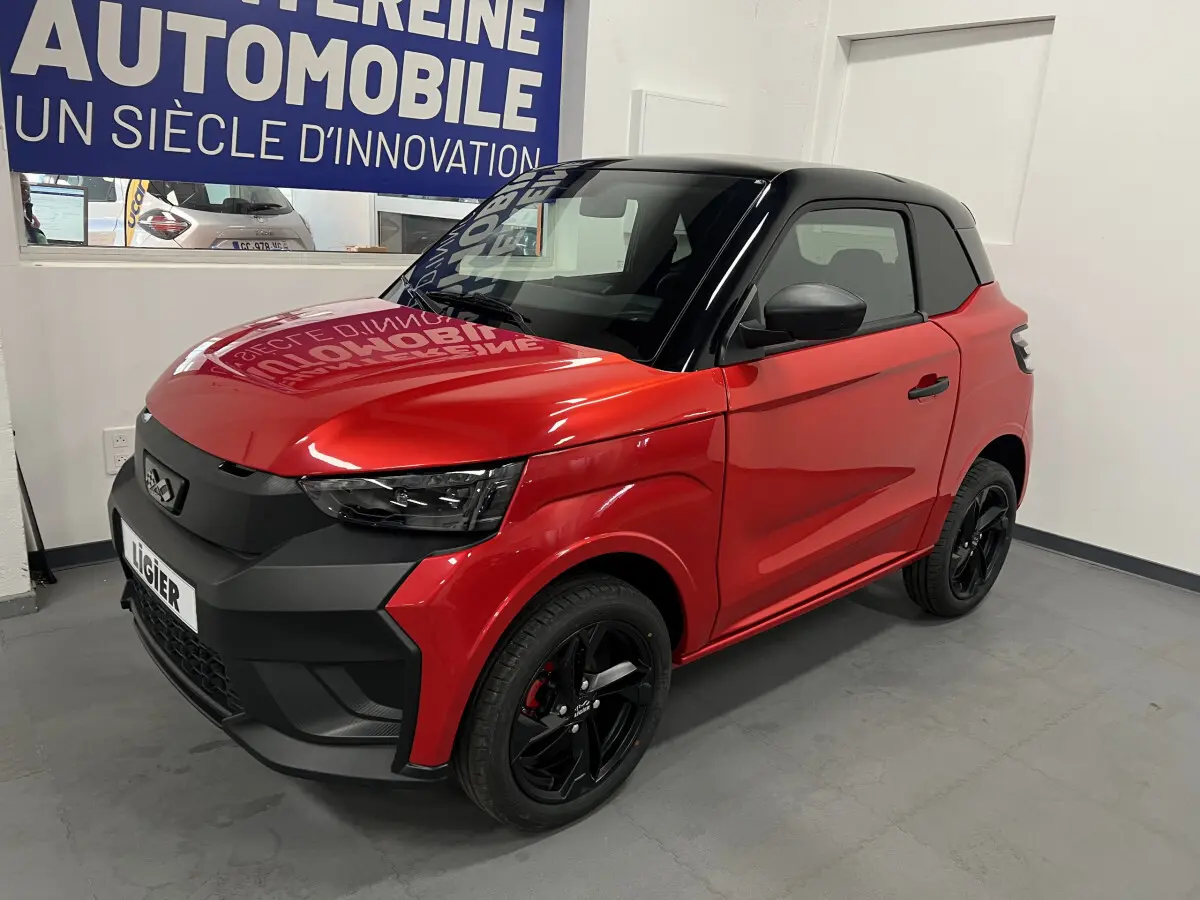 Vue 3/4 avant droite de la LIGIER JS50 BEV 8KWH ELITE rouge avec toit noir et jantes alu noires de 15 pouces.