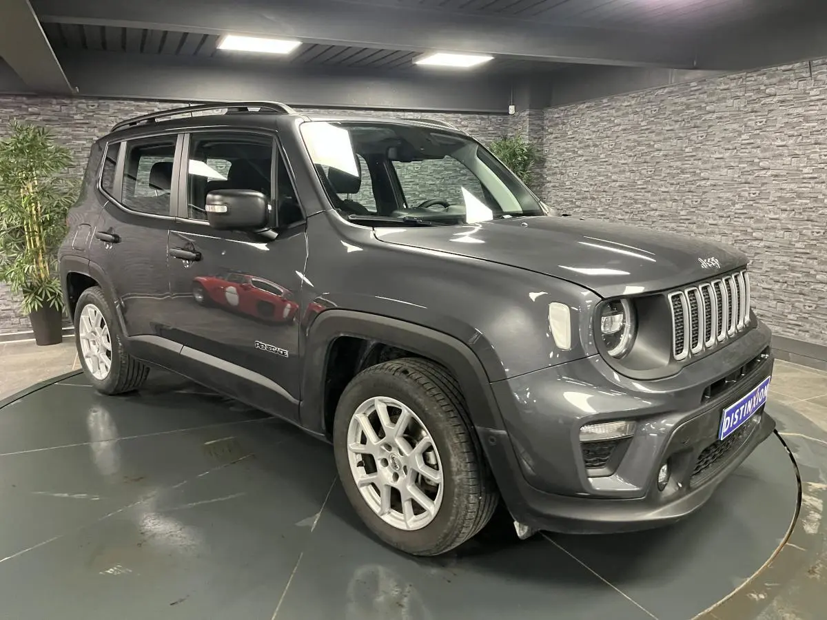 Jeep Renegade gris métallisé en 3/4 avant droit, avec calandre noir mat et jantes alliage 17 pouces visibles.