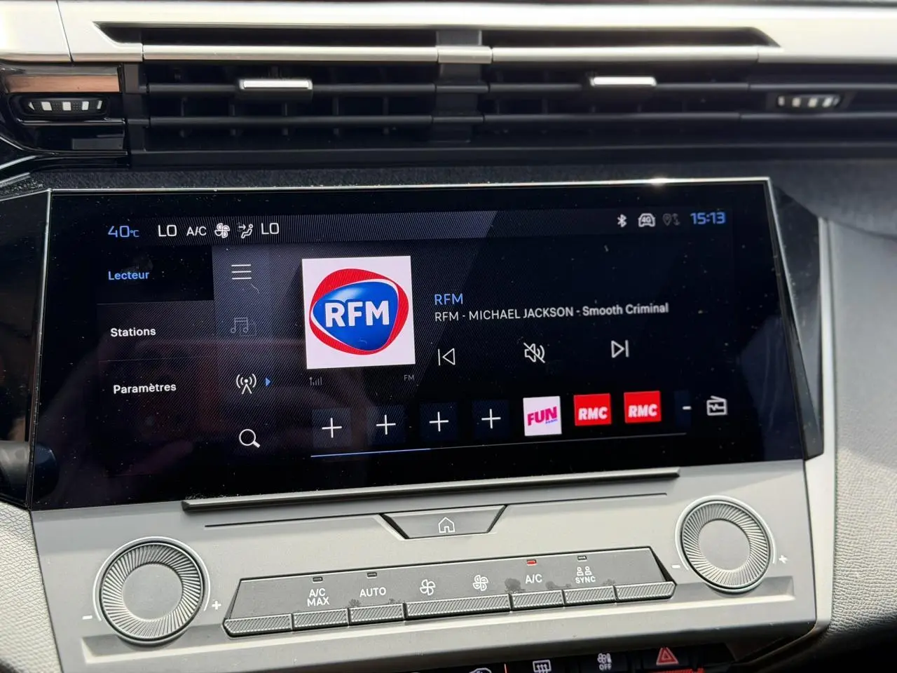 Écran tactile central 10'' du Peugeot 308 SW 2025, affichant la radio RFM, avec commandes climatisation en dessous.