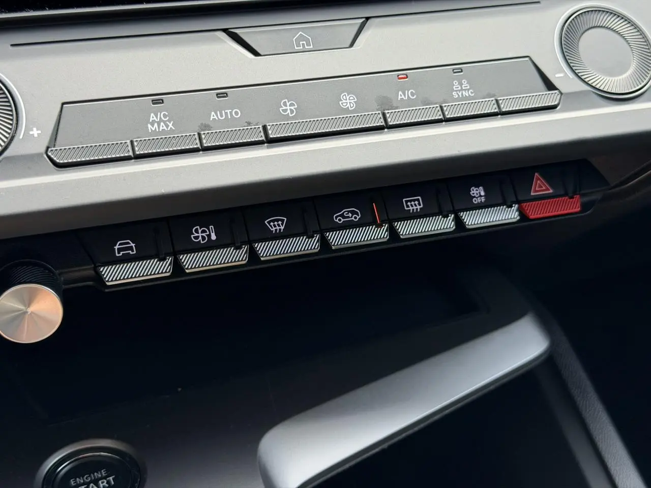 Gros plan sur la console centrale du Peugeot 308 SW 2025 gris Selenium, montrant les commandes climatisation et boutons fonctionnels.