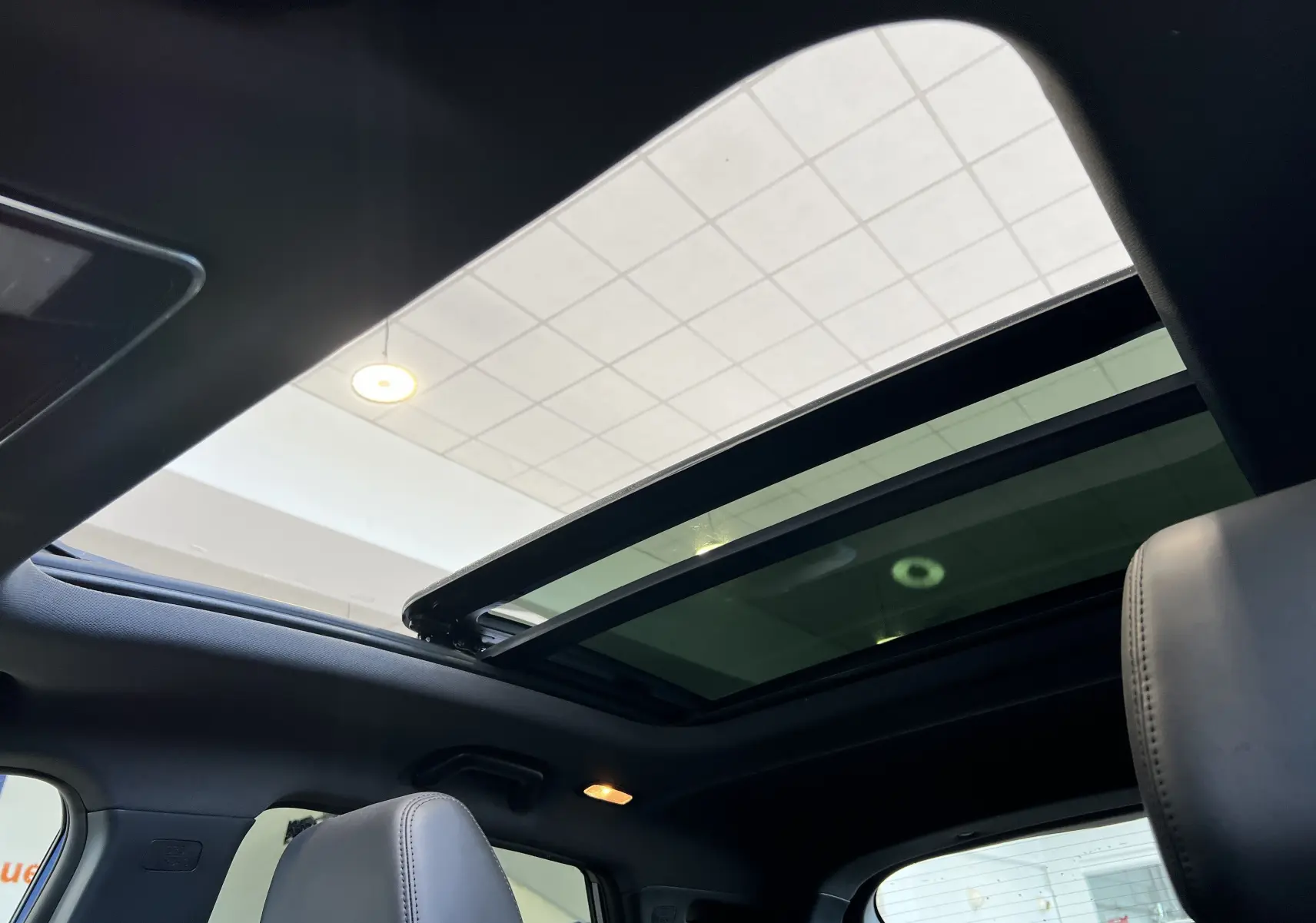 Toit ouvrant panoramique ouvert vu de l'intérieur sur les sièges noirs du SERES 3 Electric 163ch Luxe 2022.