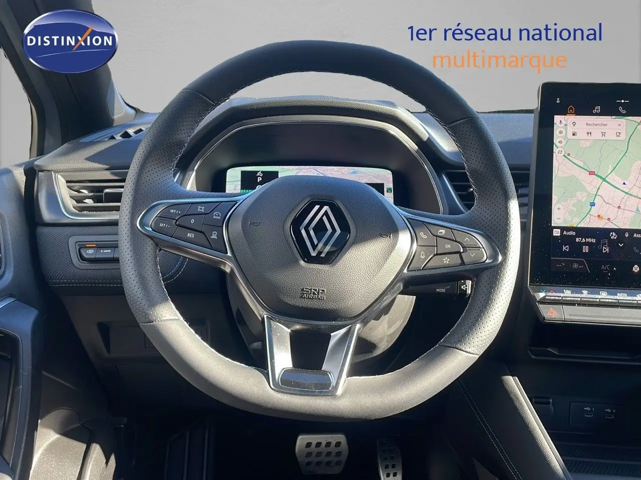 Vue intérieure centrée sur le volant cuir perforé du Renault Captur E-Tech 2025 avec écran tactile et tableau de bord numérique.