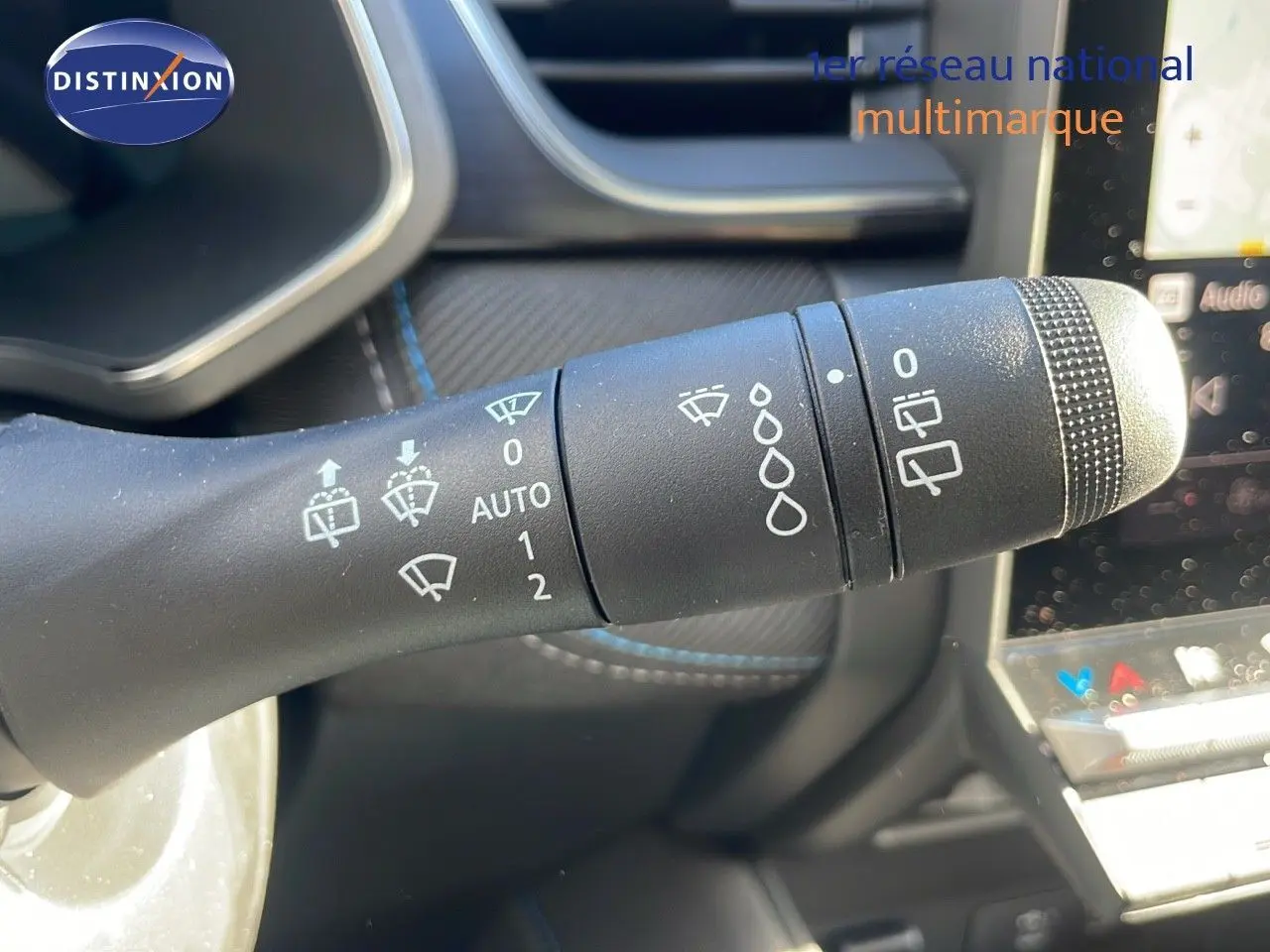 Gros plan sur la commande d'essuie-glace du Renault Captur E-Tech gris rafale, intérieur avec détails du tableau de bord.