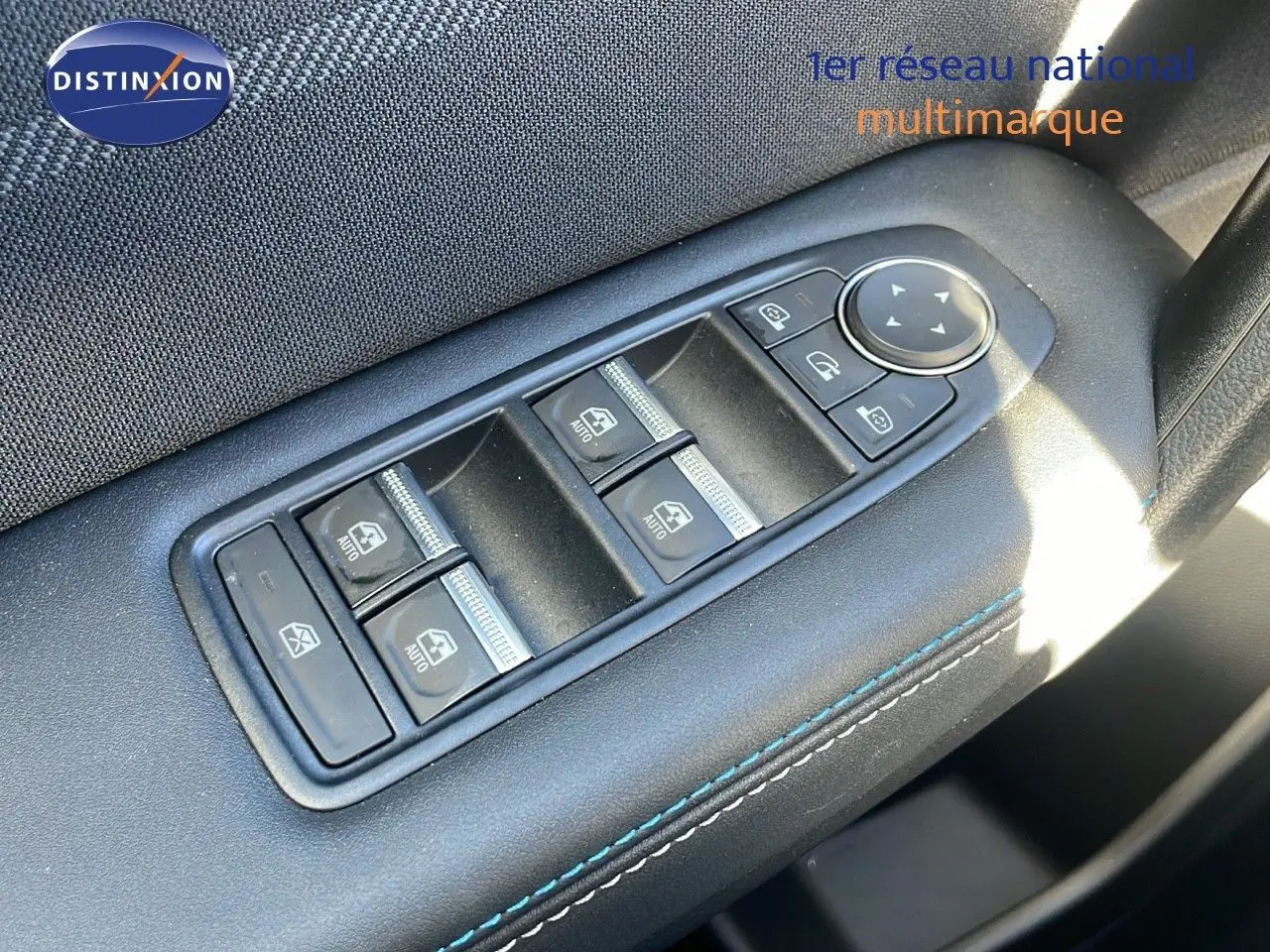 Gros plan sur les commandes des vitres électriques sur la porte côté gauche d’un Renault Captur gris Rafale 2025.