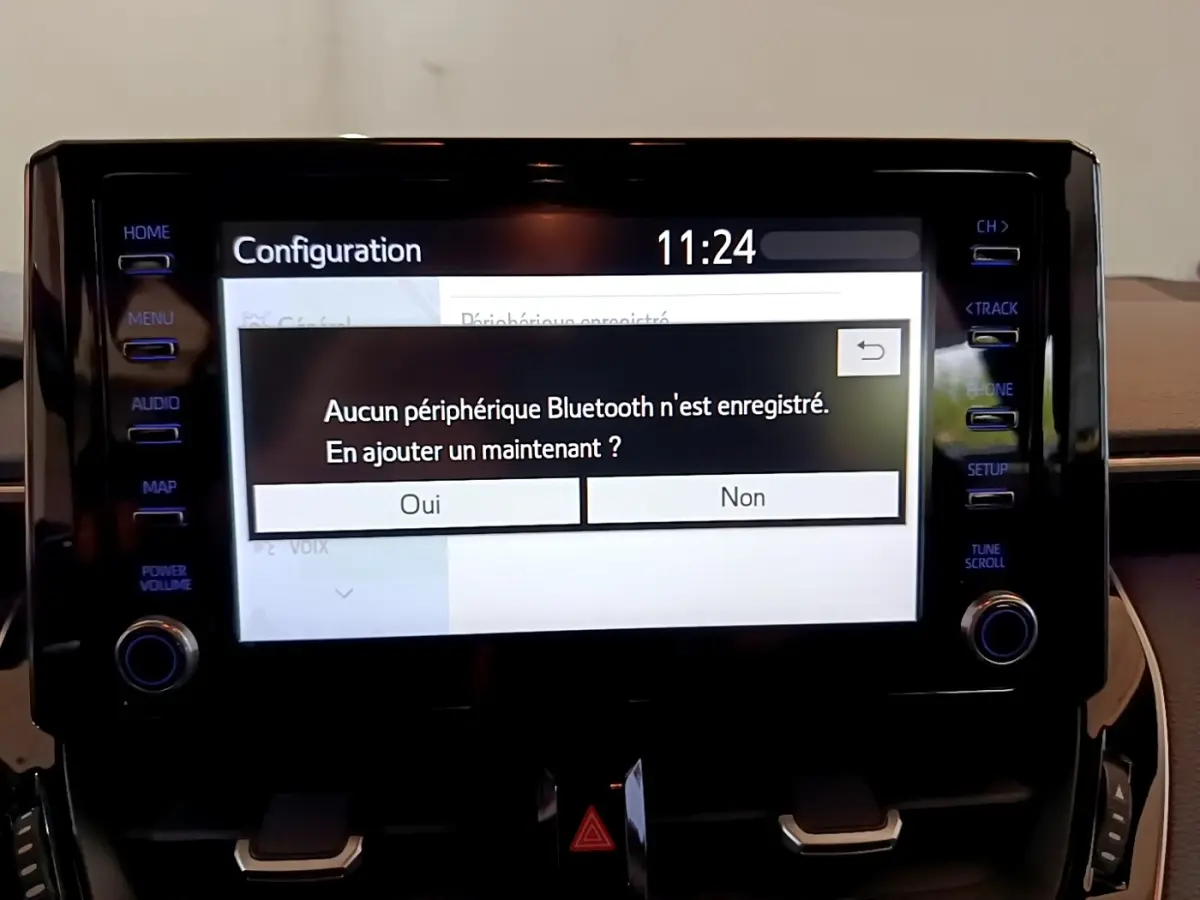 Écran tactile central de la Toyota Corolla hybride 2021 affichant un message Bluetooth, vue intérieure frontale.