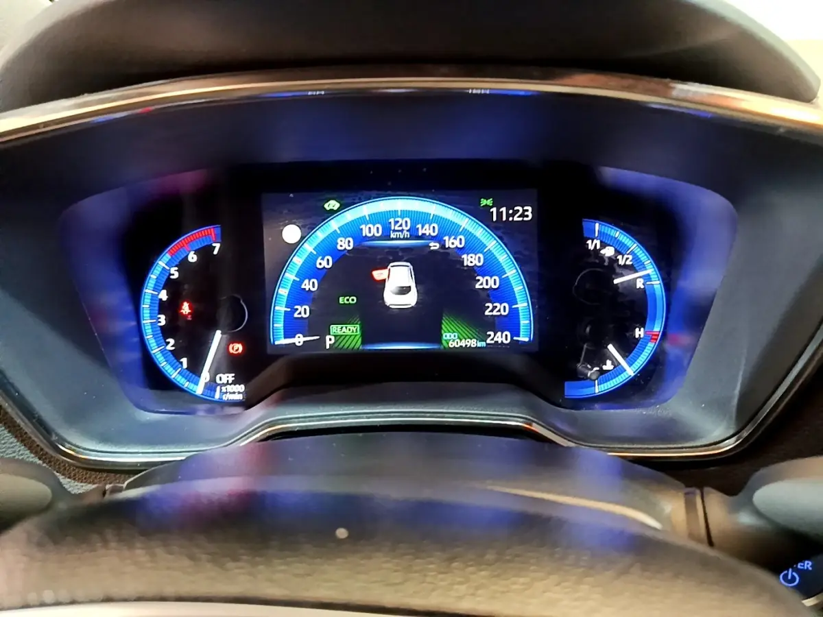 Vue rapprochée du tableau de bord numérique bleu de la Toyota Corolla Hybride 2021, affichant la vitesse et l'heure.