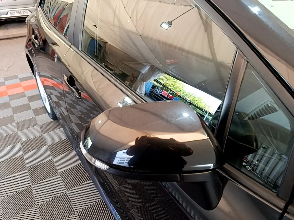 Rétroviseur côté gauche noir brillant de la Toyota Corolla hybride 2021, vue rapprochée sur la portière avant.