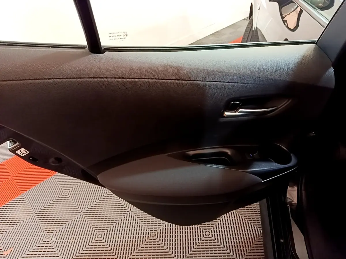 Porte arrière droite noire de Toyota Corolla hybride 2021, montrant la poignée et les commandes de fenêtre.