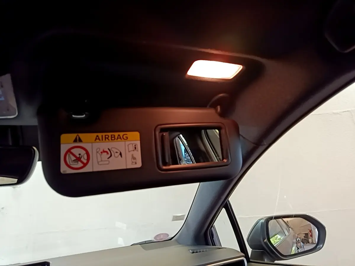 Miroir de courtoisie sur pare-soleil côté conducteur d'une Toyota Corolla hybride noire, vue intérieure avant droite.