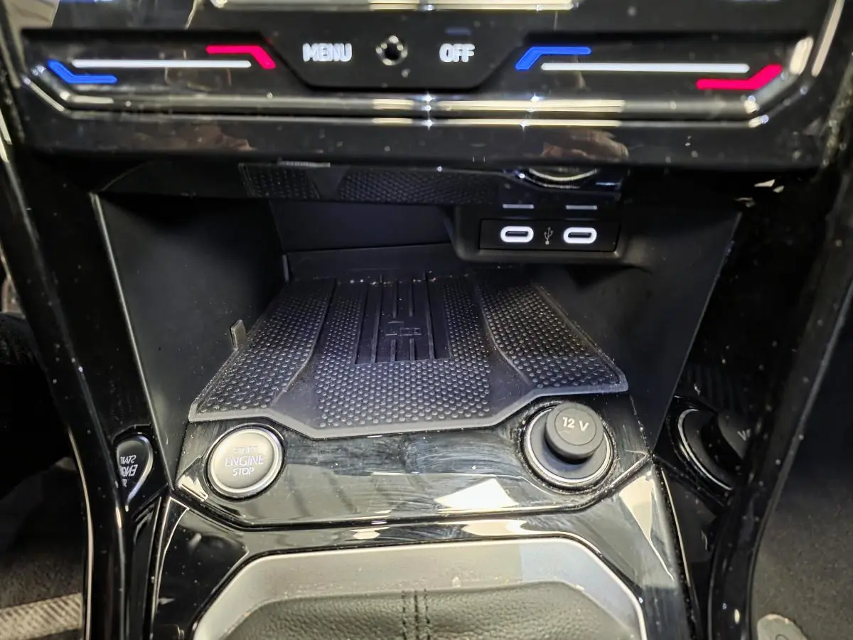 Détail de la console centrale noire brillante du Volkswagen T-Roc 1.5 TSI R-Line avec boutons start/stop et prise 12V visible.