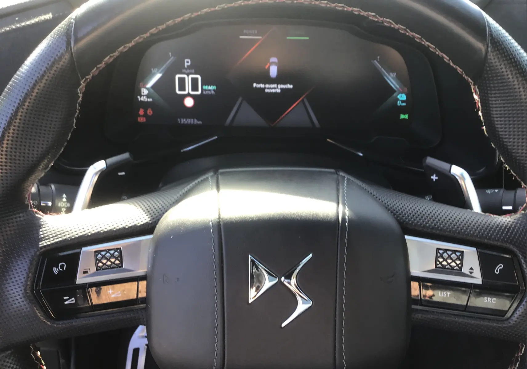 Vue intérieure centrée sur le volant en cuir noir perforé et le tableau de bord numérique du DS7 Crossback 2023.
