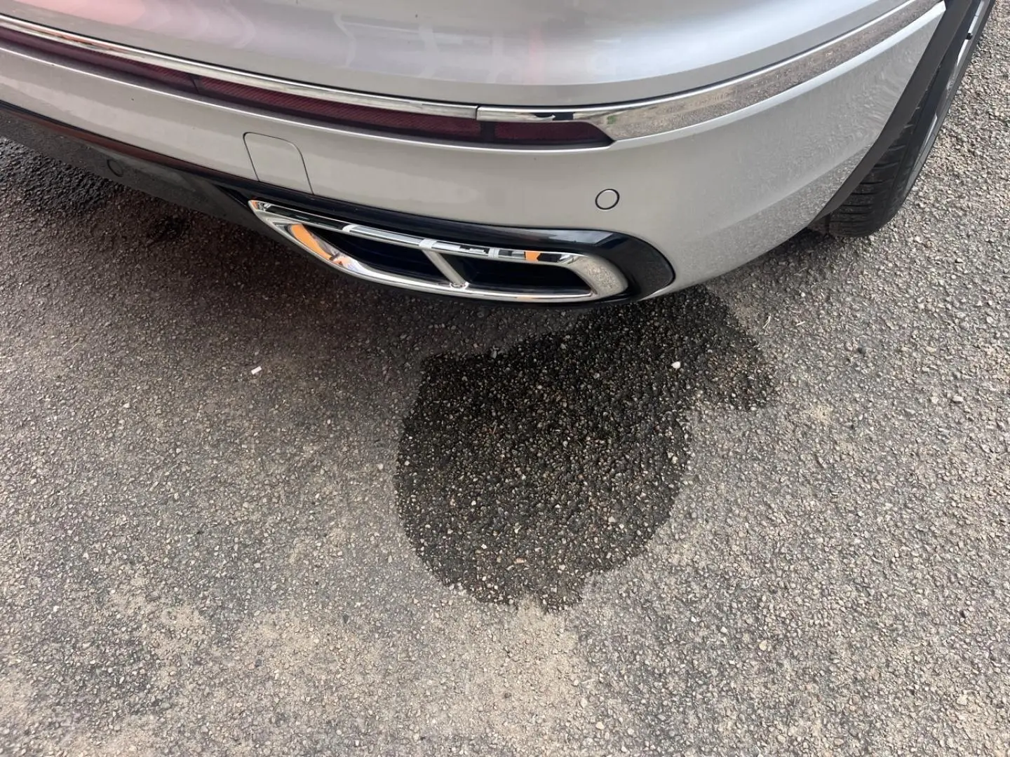 Gros plan sur la sortie d’échappement chromée arrière droite du Volkswagen Tiguan gris Dauphin métallisé.