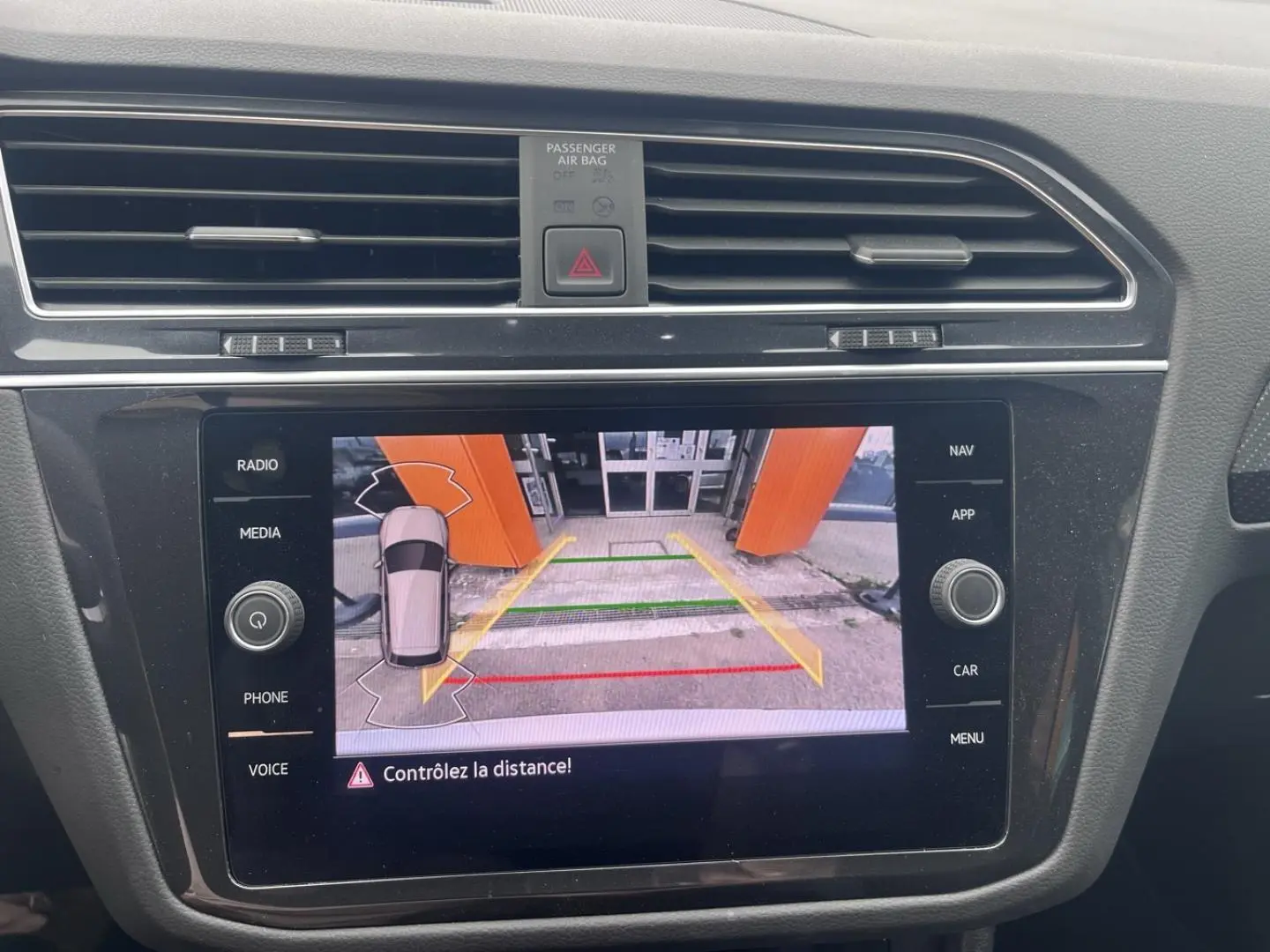 Écran tactile intérieur du Volkswagen Tiguan 1.4 eHybrid montrant la caméra de recul avec guidage coloré.