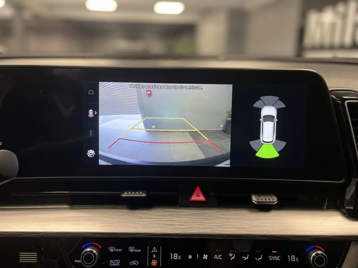 Écran tactile du tableau de bord du KIA SPORTAGE 2022 montrant la caméra de recul et l'assistance au stationnement.