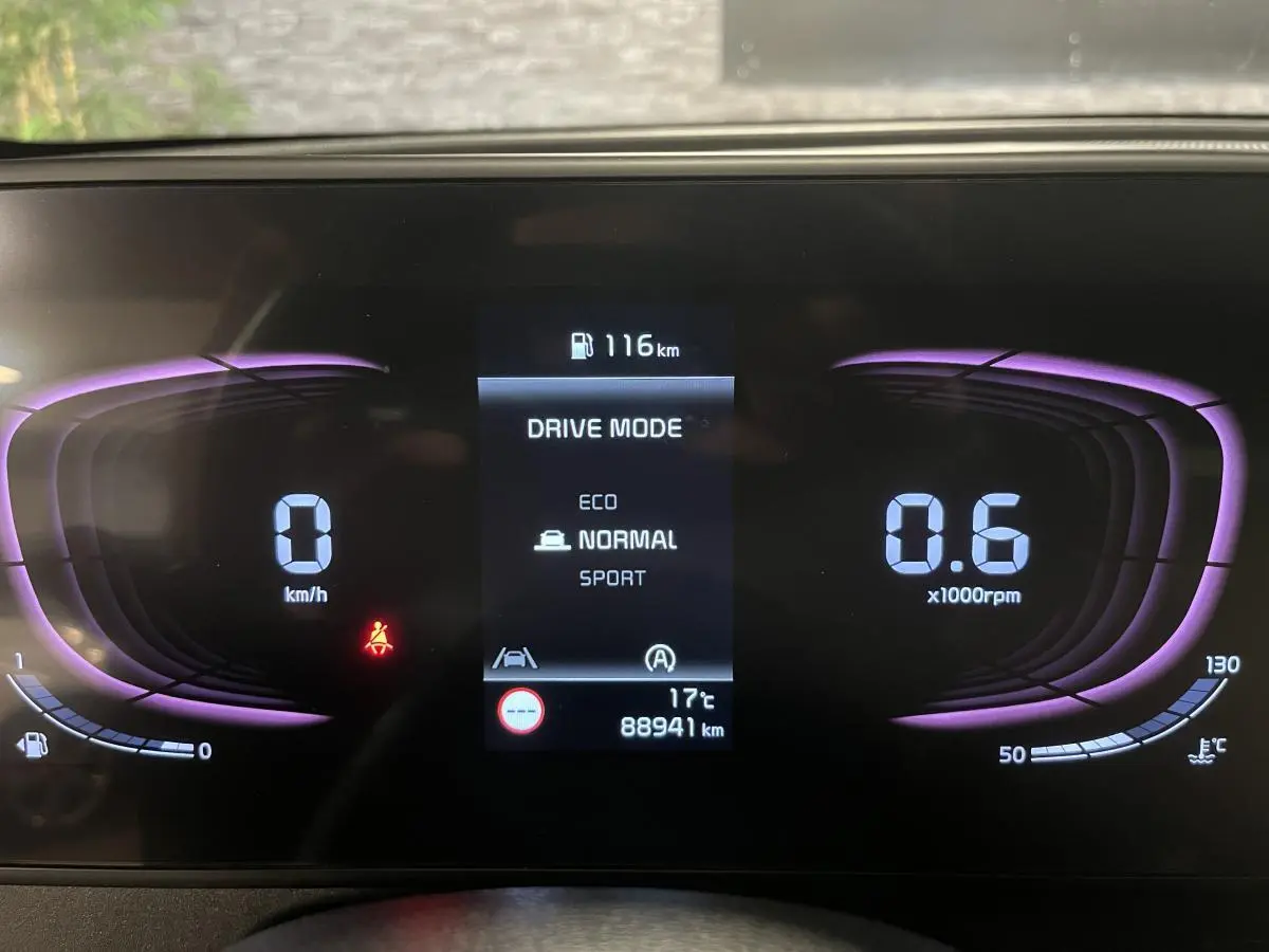 Tableau de bord numérique du Kia Sportage gris 2022 affichant mode de conduite et compte-tours violet.
