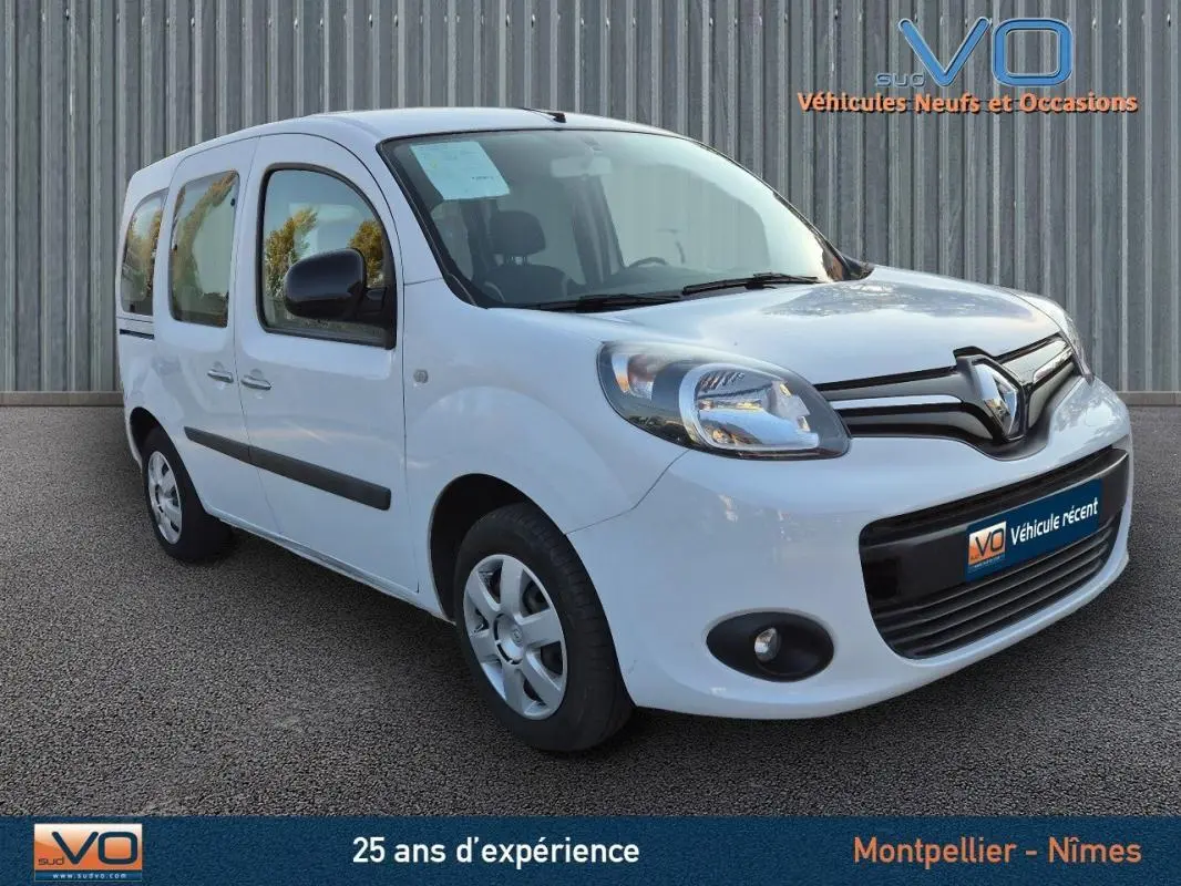 Vue 3/4 avant d'un Renault Kangoo blanc de 2016 avec porte latérale et rétroviseurs noirs sur fond neutre.