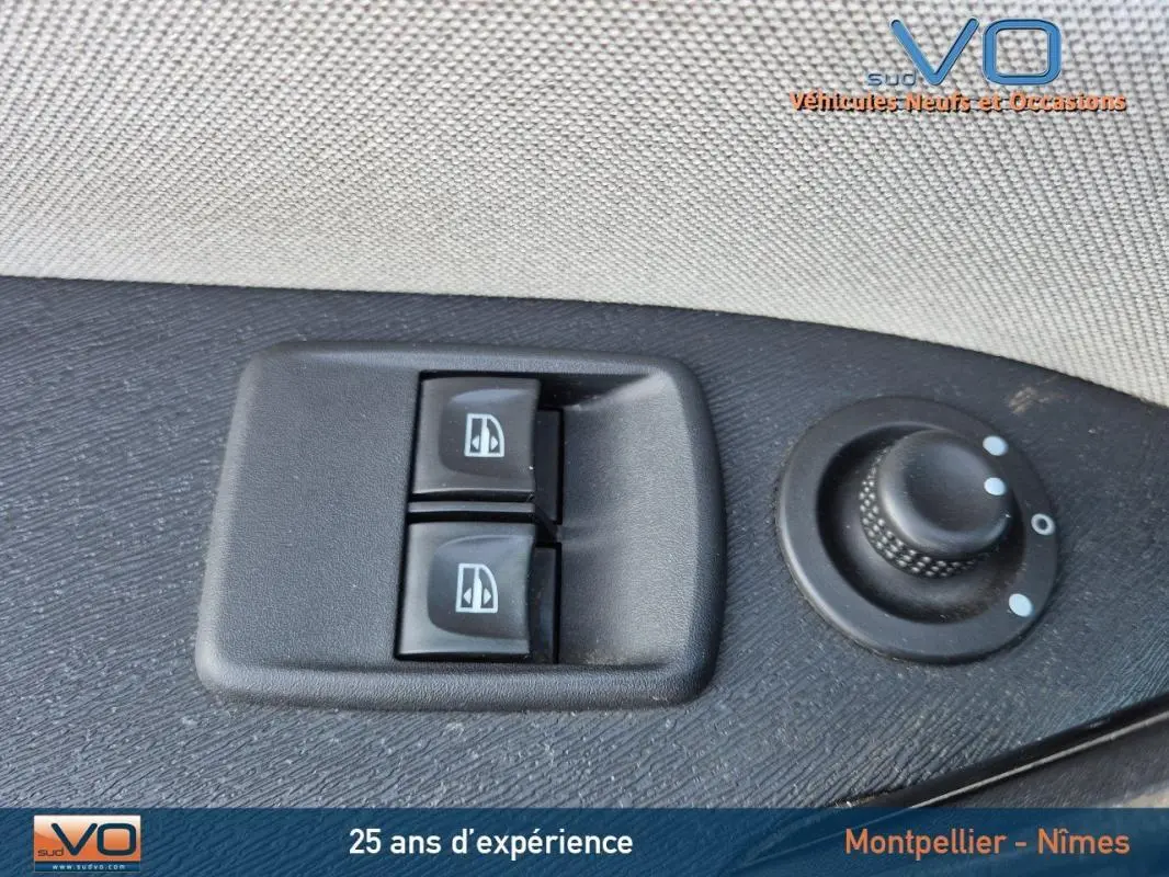 Gros plan sur les commandes électriques des vitres et réglage des rétroviseurs côté conducteur du Renault Kangoo blanc 2016.