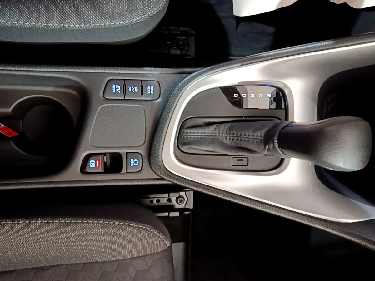 Gros plan sur la console centrale de la Toyota Yaris hybride 2021, avec levier de vitesse automatique et boutons de contrôle.