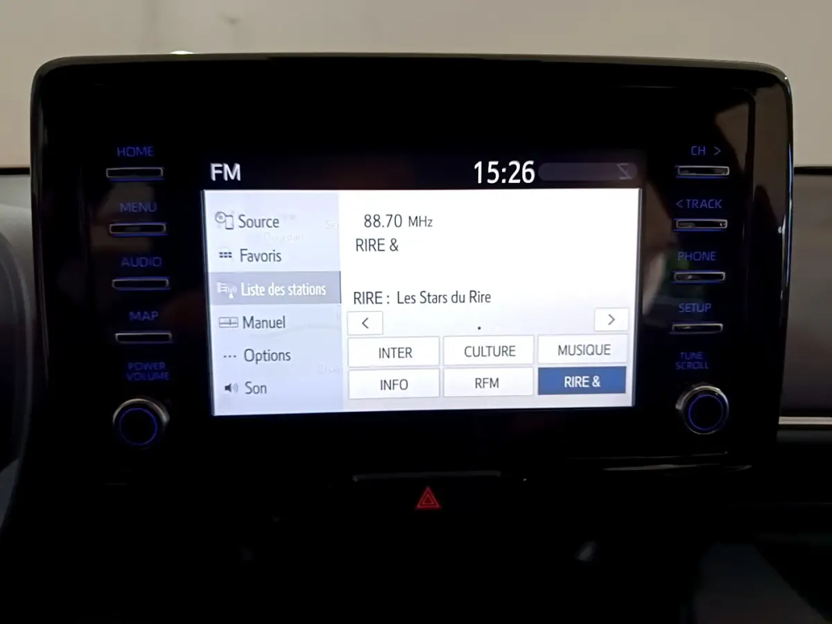Écran tactile central allumé de la Toyota Yaris hybride 2021, affichant la liste des stations radio FM.