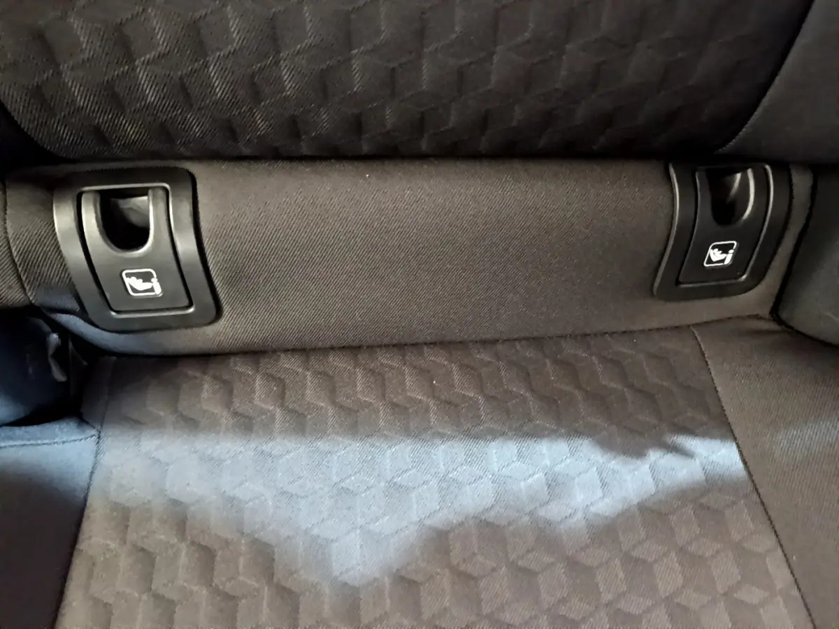 Gros plan sur la banquette arrière gris foncé de la Toyota Yaris hybride, montrant les attaches Isofix intégrées.