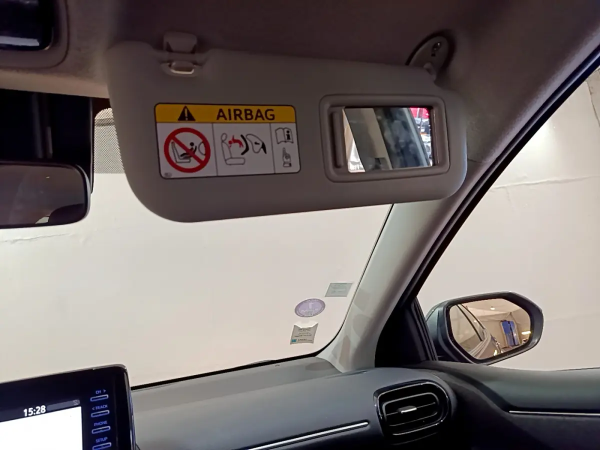 Détail intérieur sur le pare-soleil côté conducteur de la Toyota Yaris hybride 2021 avec miroir et avertissement airbag.