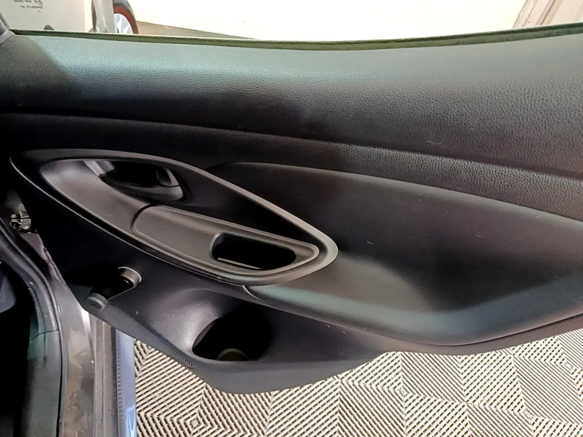 Vue rapprochée de la porte côté gauche noire de la Toyota Yaris Hybride 116h 2021 avec poignée intégrée et rangement.