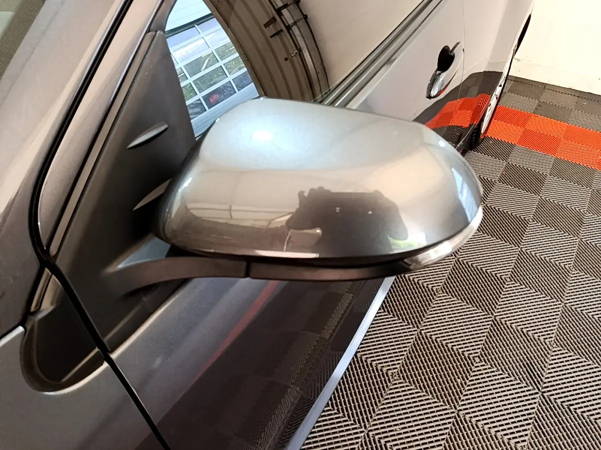 Rétroviseur côté gauche gris clair de la Toyota Yaris hybride 2021, avec poignée de porte et reflet intérieur visible.