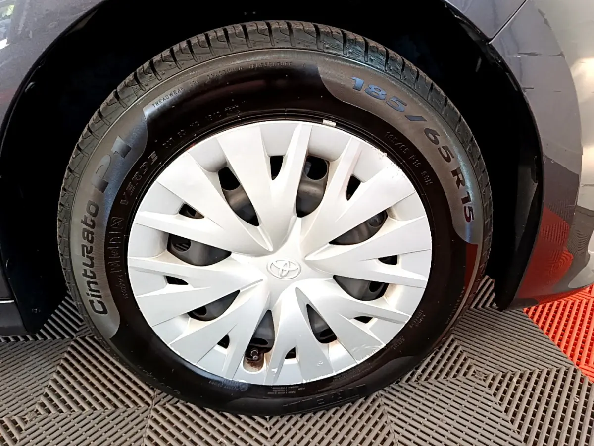 Gros plan sur la roue avant gauche grise d'une Toyota Yaris hybride 2021 avec enjoliveur blanc et pneu Cinturato P1.