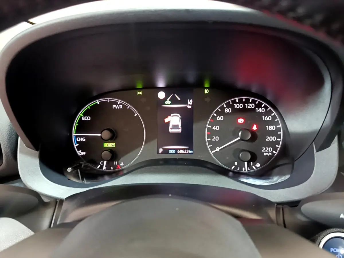 Vue rapprochée du tableau de bord numérique de la Toyota Yaris hybride 2021, affichage des compteurs et indicateurs.