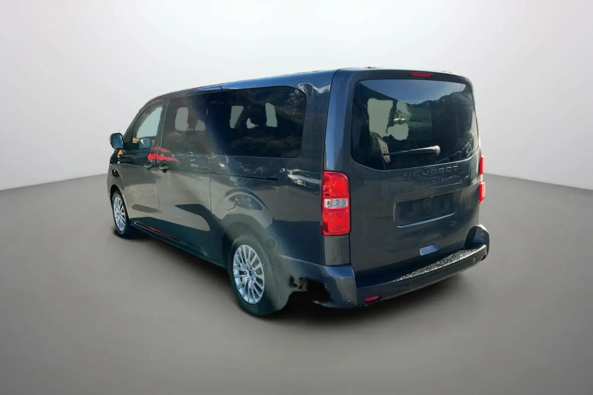Vue 3/4 arrière droite d'un Peugeot Traveller gris titane avec vitres surteintées et jantes tôle 17 pouces.