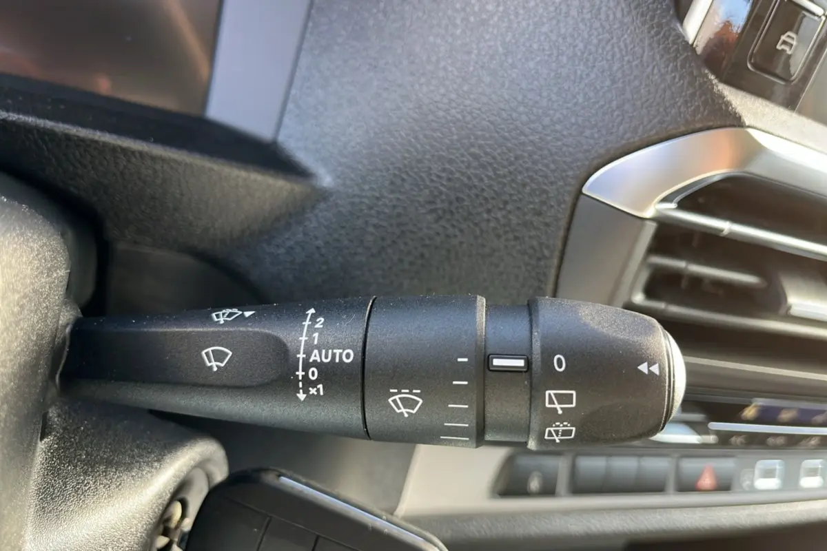Gros plan sur la commande des essuie-glaces côté gauche du tableau de bord du Peugeot Traveller gris titane 2025.