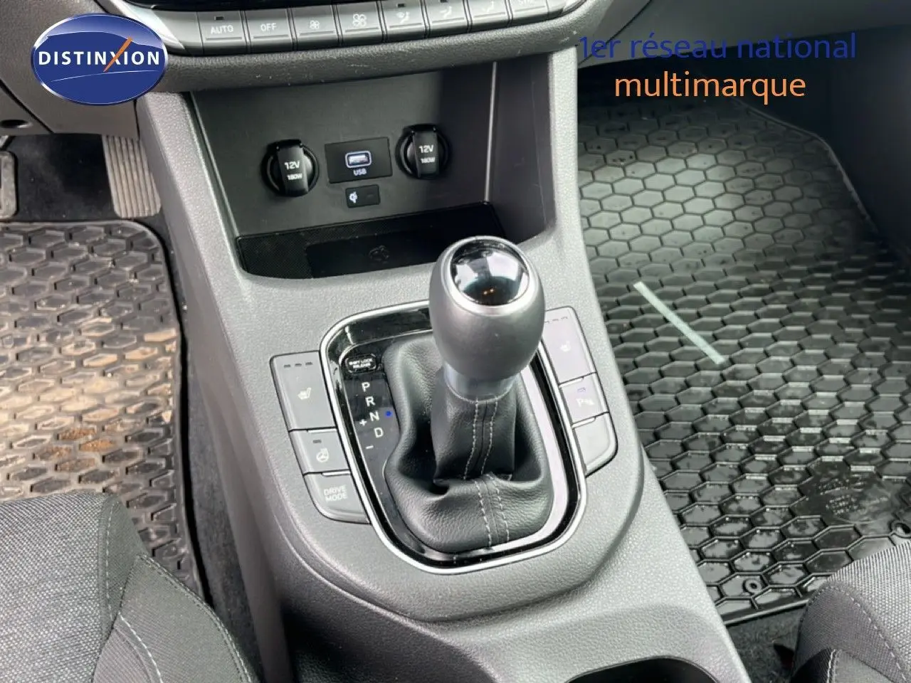 Vue rapprochée de la console centrale avec levier de vitesse et prises USB d’une Hyundai i30 SW rouge intérieur noir.