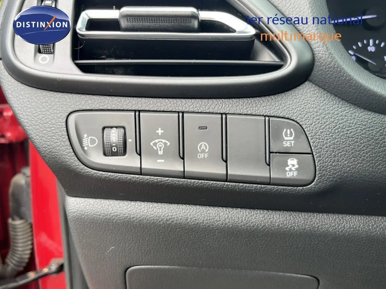 Gros plan sur les commandes de réglage du tableau de bord côté gauche d’une Hyundai i30 SW rouge Sunset Red 2023.