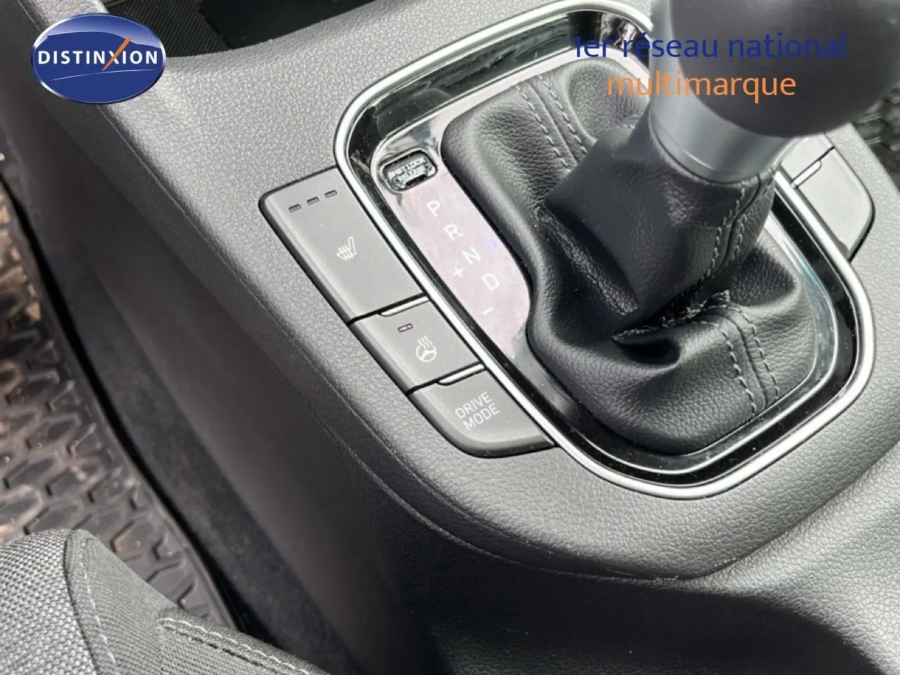 Gros plan sur la console centrale de la Hyundai i30 SW 2023 avec levier de boîte automatique et boutons de chauffage de sièges.