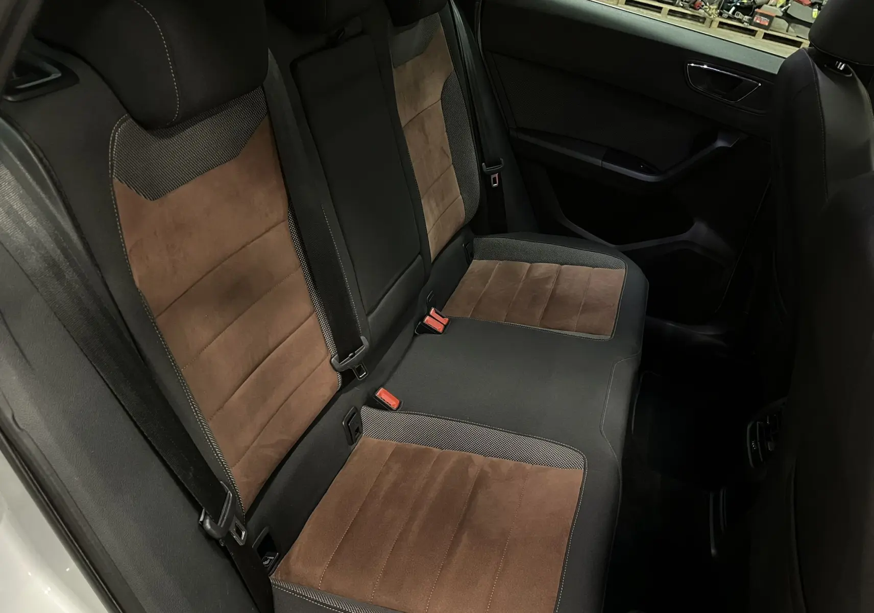 Vue intérieure arrière du SEAT Ateca 2016, sièges bicolores marron et noir avec ceinture de sécurité visible.