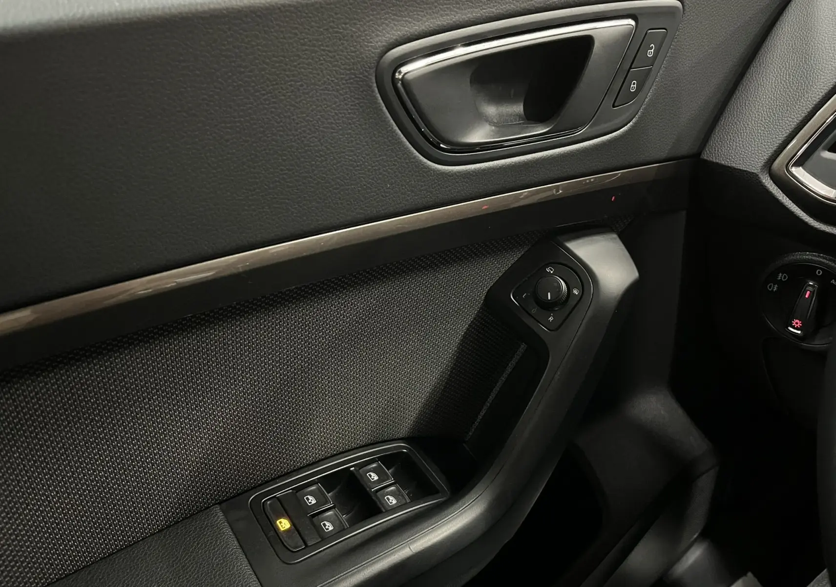 Vue rapprochée de la porte avant gauche noire du SEAT Ateca 2016, avec commandes de vitres et rétroviseurs.