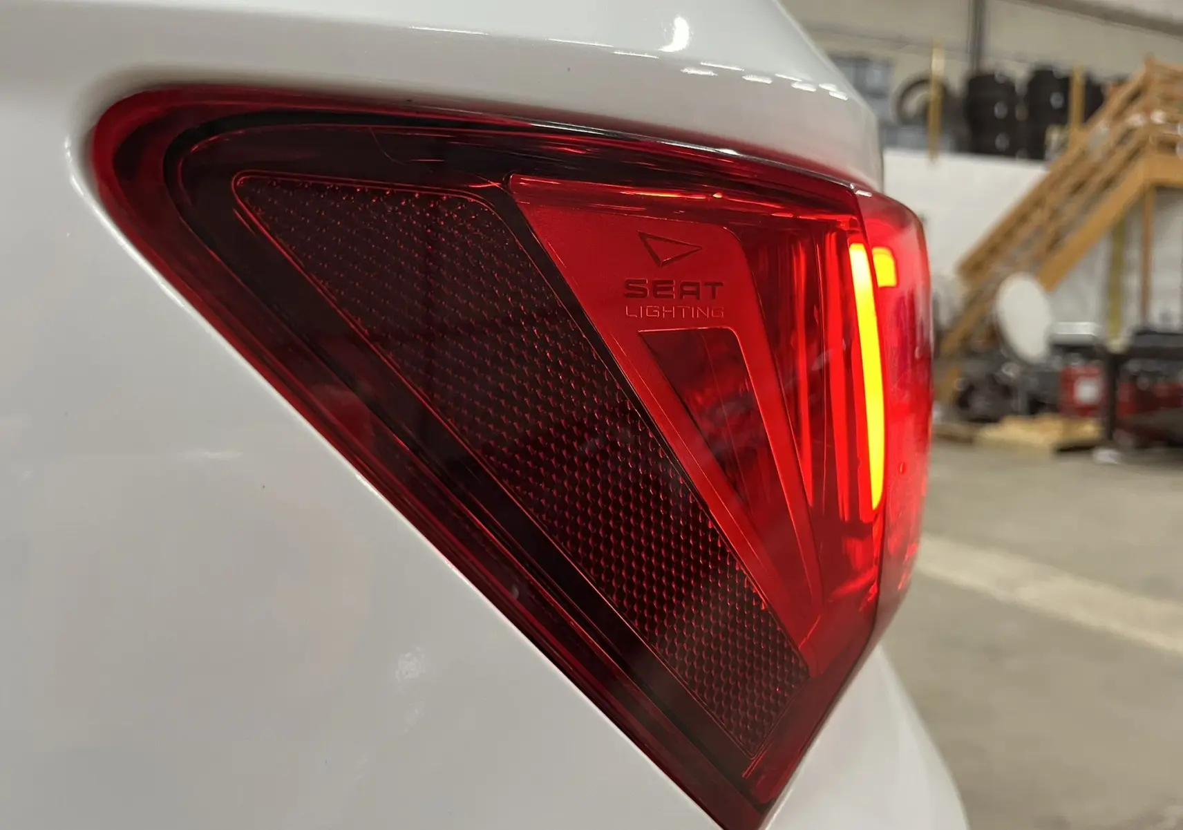Gros plan sur le feu arrière droit rouge du SEAT Ateca blanc, avec marquage SEAT Lighting visible.