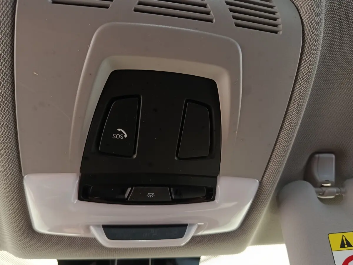Vue intérieure du plafonnier gris clair de la BMW Série 2 Gran Tourer F46 avec bouton SOS et éclairage intégré.