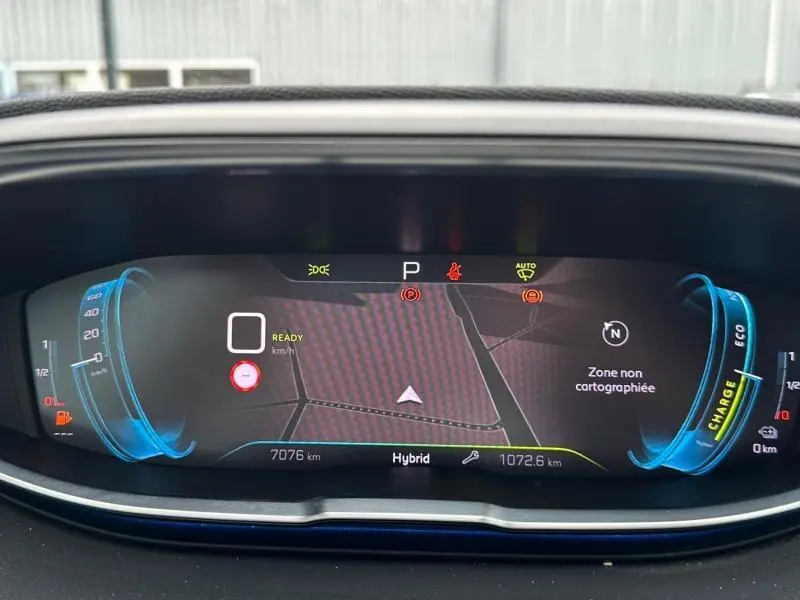 Tableau de bord numérique du Peugeot 3008 hybride 2024 affichant la vitesse à zéro et la carte de navigation.