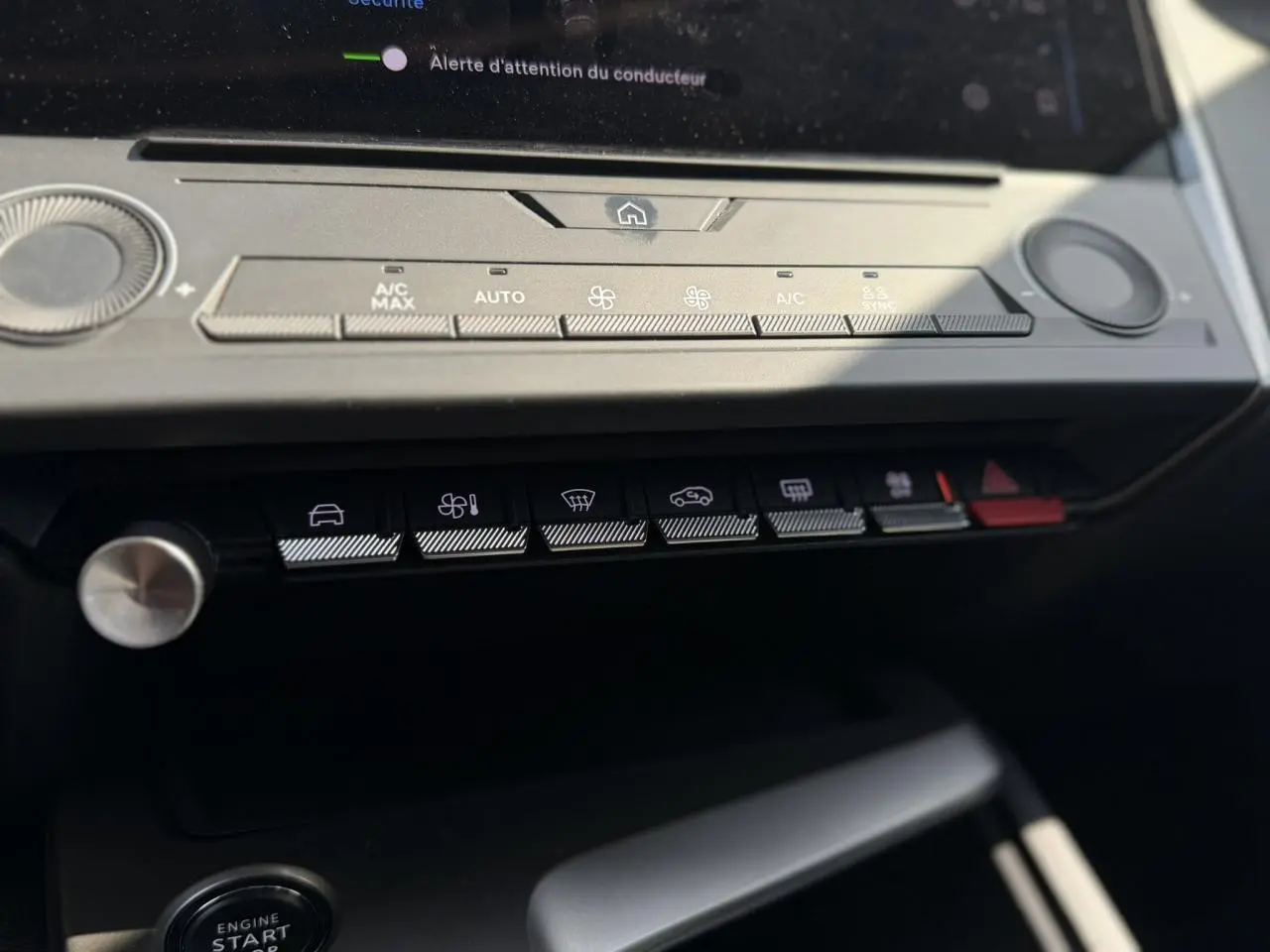 Gros plan sur la console centrale de la Peugeot 308 SW 2025, boutons de climatisation et démarrage sans clé visibles.