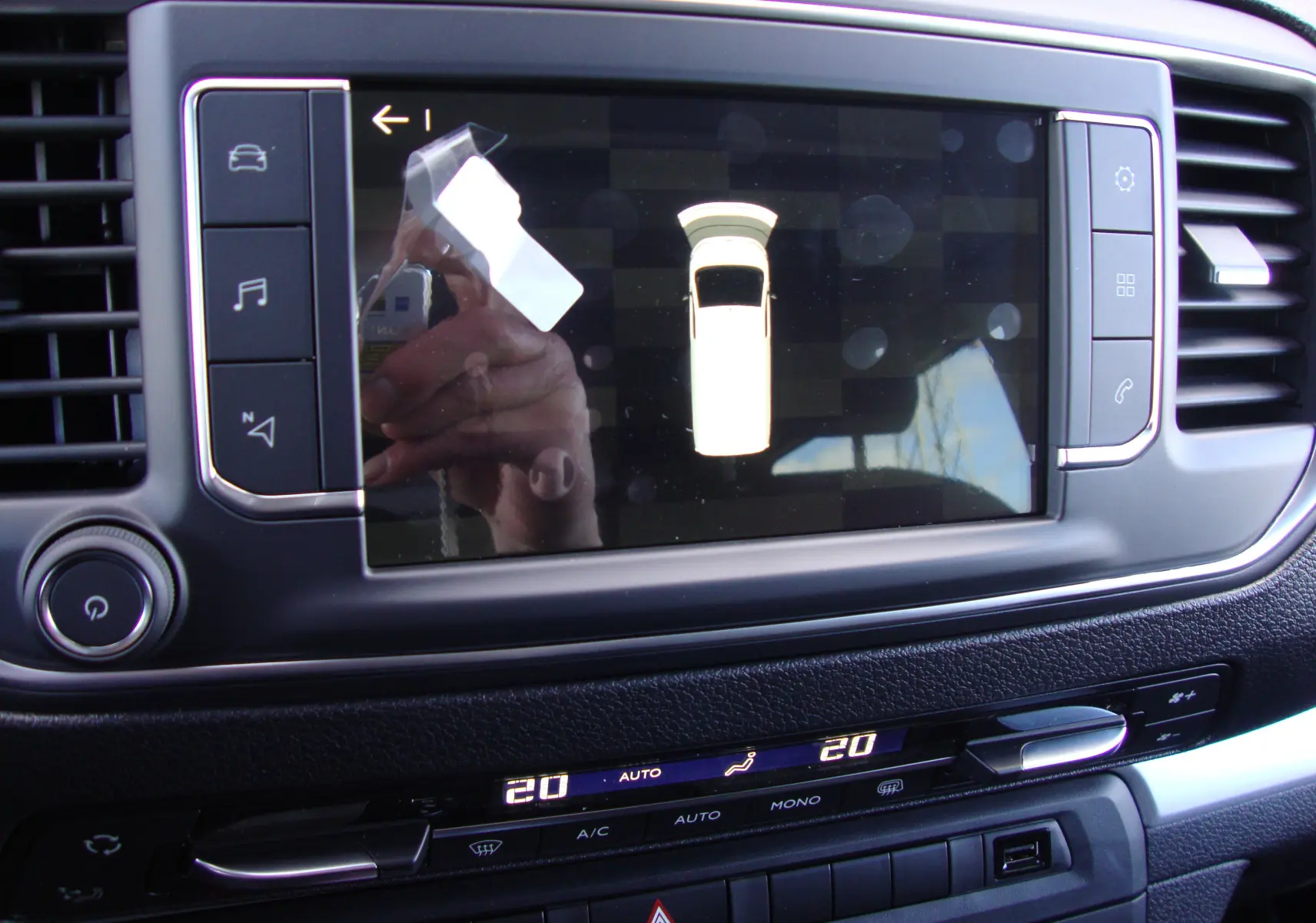 Vue rapprochée de l'écran tactile central du Citroën Jumpy XL gris platinum, affichant l'aide au stationnement.