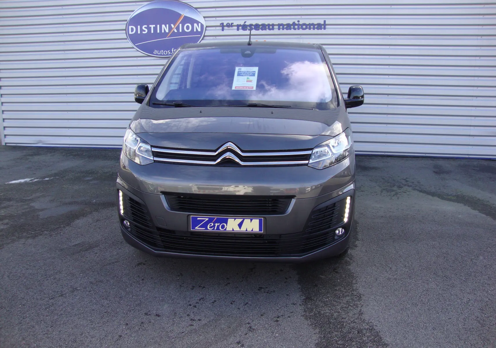 Vue frontale d'un Citroën Jumpy Cabine Approfondie gris platinum avec feux diurnes LED allumés sur un parking.