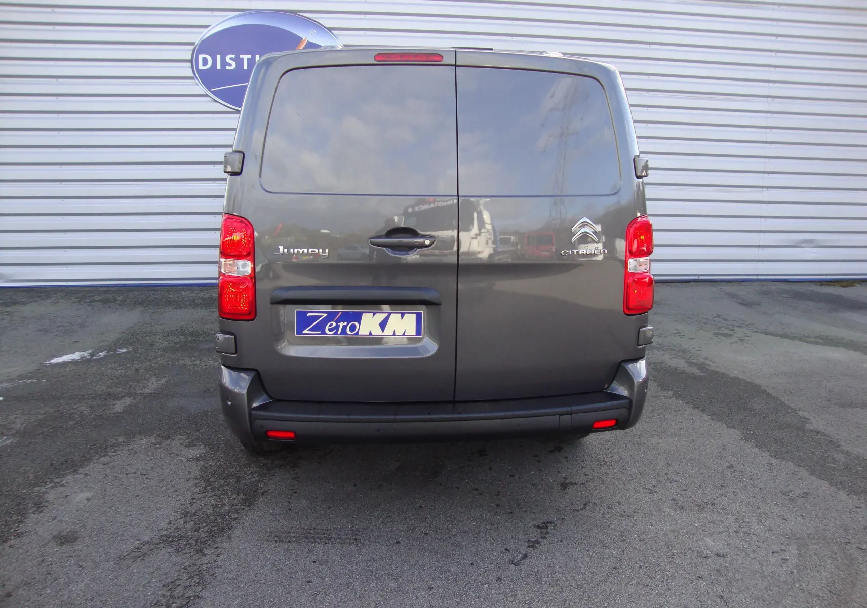 Vue arrière d'un Citroën Jumpy Cabine Approfondie gris platinum avec portes battantes et feux rouges visibles.