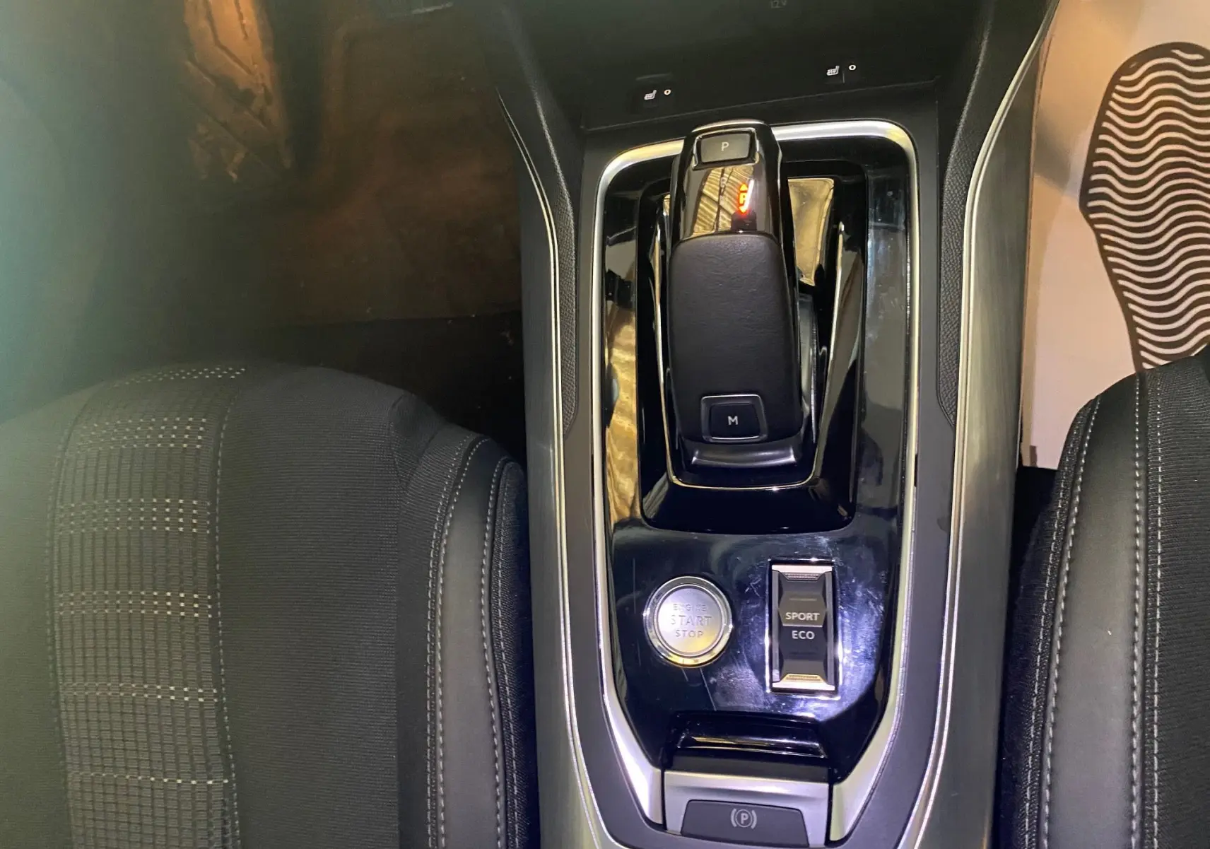 Vue plongeante sur la console centrale noire et levier de vitesse de la Peugeot 308 Allure blanche de 2020.