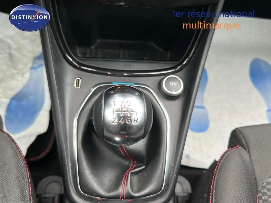 Gros plan sur le levier de vitesses manuel du Ford Puma rouge 2020 avec surpiqûres rouges et prise 12V.