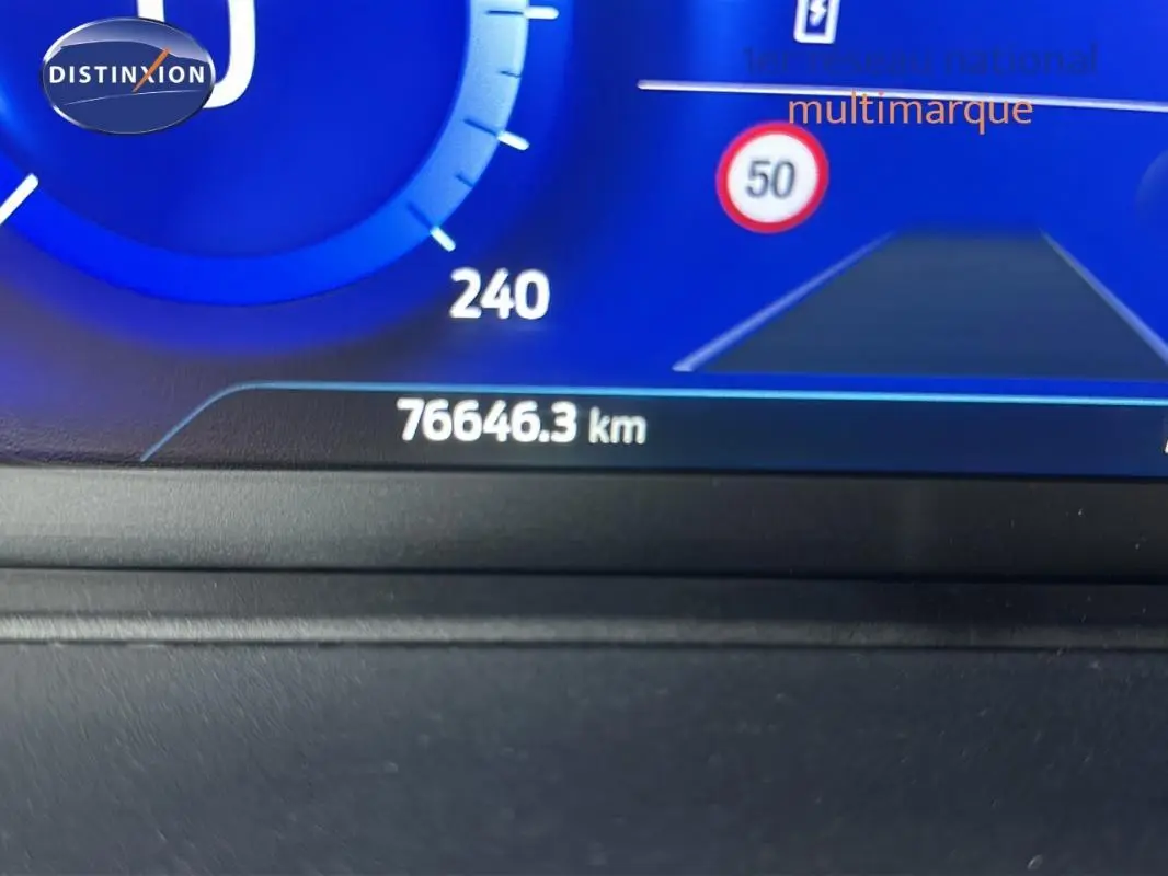 Compteur digital affichant 76 646 km et panneau de limitation à 50 km/h sur Ford Puma rouge 3/4 avant.