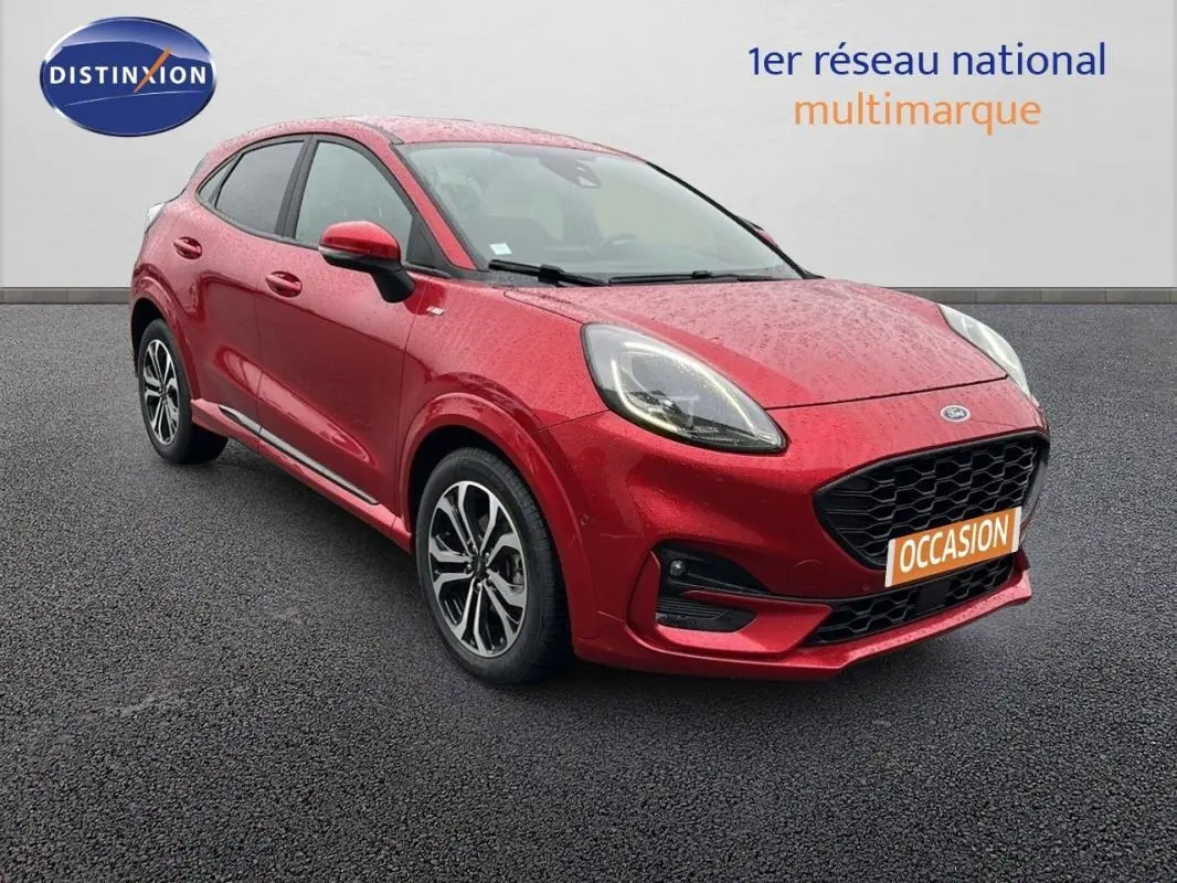 Ford Puma rouge vue 3/4 avant droit avec jantes alliage 17 pouces et calandre noire en arrière-plan neutre.